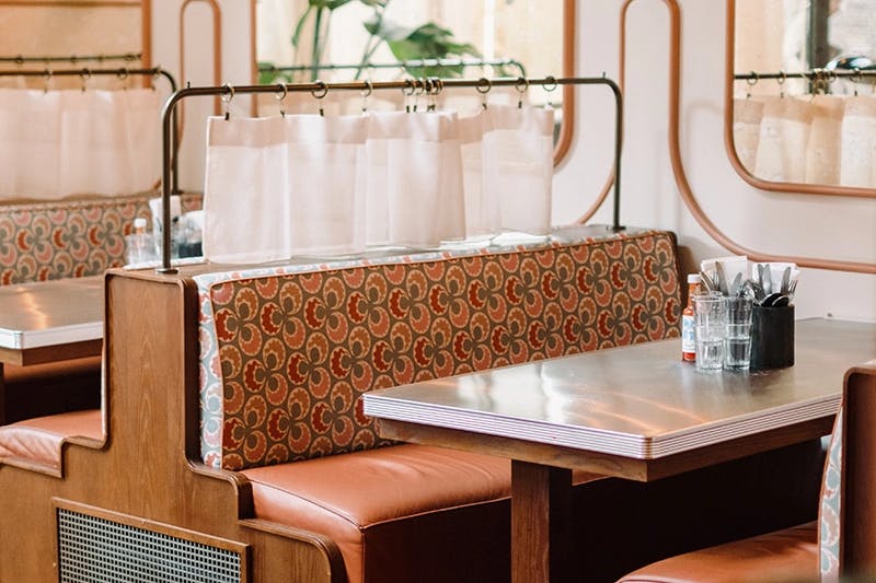 A booth in the style of a traditional American diner waits to seat four